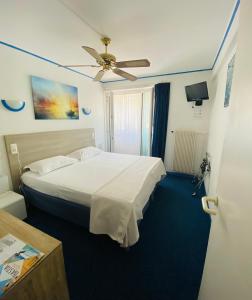 Habitación de hotel con cama y ventilador de techo. en Hotel Cyrnea en Bastia