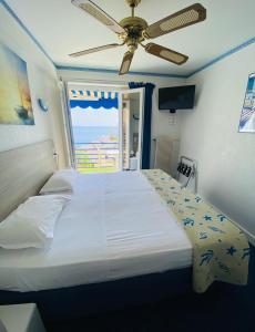 a bedroom with a large bed with a view of the ocean at Hotel Cyrnea in Bastia
