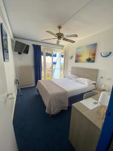 a bedroom with a bed and a ceiling fan at Hotel Cyrnea in Bastia +48 photos