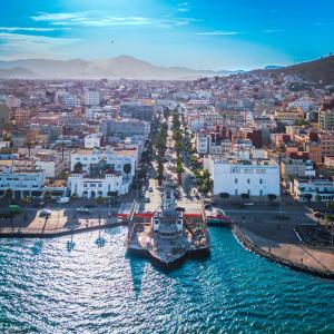a large boat is docked in the water near a city at Hotel L'Aéroport in Nador