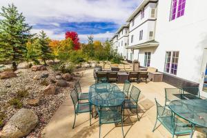 a patio with tables and chairs in a yard at River Hills Hotel- Mankato in Mankato