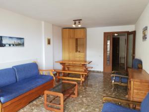 薩洛的住宿－Cala Llenguadets，客厅配有蓝色的沙发和桌子