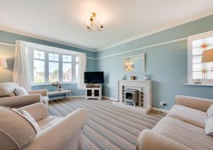 a living room with two couches and a fireplace at Preston Down in Paignton