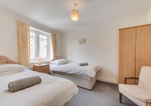 a bedroom with two beds and a chair at Abbey Mews in Torquay