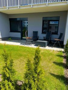 a yard with two chairs and a table and a house at Apartament Termalny in Uniejow