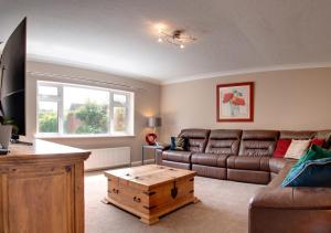 a living room with a couch and a table at The Firs in Churston Ferrers