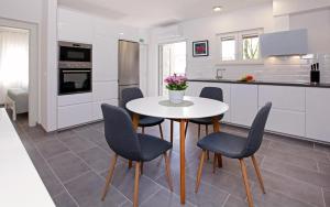 a kitchen with a table and chairs in a kitchen at Santa Cruz Apartments Supetar in Supetar