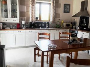 a kitchen with a wooden table and chairs and a table and a table at VILLA IRIS in Vryses
