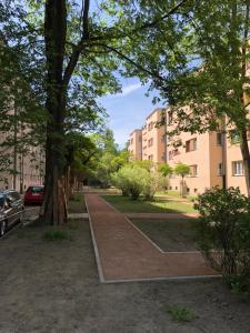 a sidewalk in a park with trees and buildings at Silver Apartments - Orientarium,Aquapark Fala & Park in Łódź
