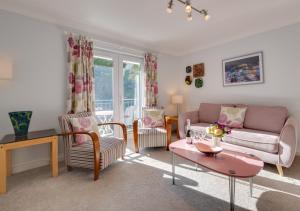 a living room with a couch and chairs and a table at 4 Hesketh Mews in Torquay