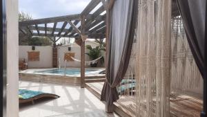 a patio with a hammock and a swimming pool at MobilHome de Charlotte - Camping La Falaise 4 étoiles in Narbonne-Plage