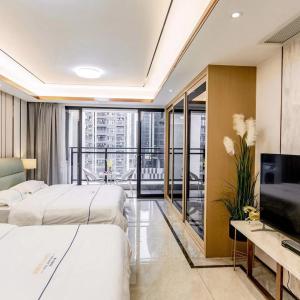 een hotelkamer met 2 bedden en een televisie bij Shengang Executive Apartment - Baoan International Airport Bihaiwan Subway Station in Bao'an