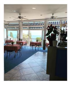 un restaurante con mesas y sillas y vistas al océano en Hotel Cyrnea, en Bastia