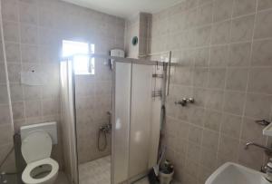 a bathroom with a shower and a toilet and a sink at Adventurous Local Hostel in Fethiye