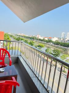 balcón con mesa, sillas y vistas al río en Khách Sạn Sông Lô, en Hải Dương