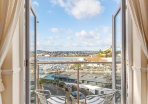 a balcony with chairs and a view of a harbor at Riviera in Torquay