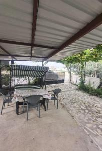 eine Terrasse mit 2 Bänken, einem Tisch und Stühlen in der Unterkunft Adventurous Local Hostel in Fethiye