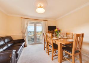 a dining room with a table and a couch at Riviera in Torquay