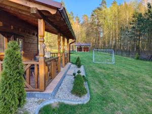 ein Blockhaus mit einem Fußballtor im Hof in der Unterkunft DOMEK AGA in Kruklanki