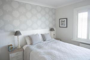 a bedroom with a bed with a white comforter at Strandene (63 Strand Road) in Portstewart