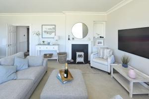 a living room with a couch and a fireplace at Strandene (63 Strand Road) in Portstewart