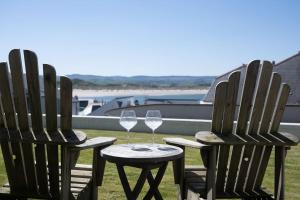 two chairs and a table with wine glasses at Strandene (63 Strand Road) in Portstewart