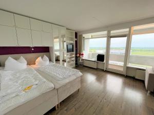 - une grande chambre avec un grand lit et de grandes fenêtres dans l'établissement Panoramic A15-8 - Panoramic, à Sierksdorf
