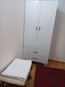 a room with a white cabinet and a rug at Sunshine Guest house with terrace in Fethiye