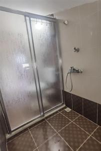 a shower with a glass door in a bathroom at Sunshine Guest house with terrace in Fethiye