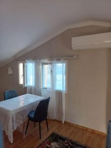 ein Esszimmer mit einem weißen Tisch und 2 Stühlen in der Unterkunft Sunshine Guest house with terrace in Fethiye