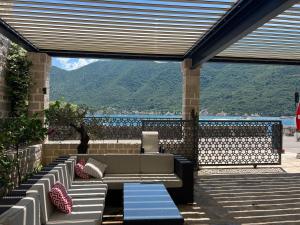 a patio with a couch and a view of the water at Beachfront Villa Perast in Perast