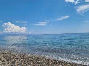 Alba di luna في سانتا تيريزا دي ريفا: شاطئ حصو مع المحيط في الخلفية