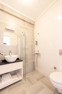 a white bathroom with a sink and a toilet at Bouti Ayvalık in Ayvalık +68 photos