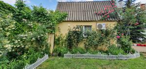 a house with a white picket fence in the yard at Holiday Home near sea in Odesa