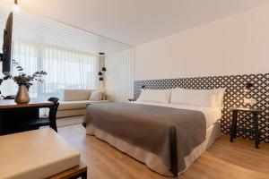 Un dormitorio con una cama grande y un sofá. en Magnolia Hotel - Adults Only, en Salou