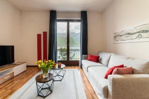ein Wohnzimmer mit einem Sofa und einem TV in der Unterkunft 76 The Lake House - Lugano in Melide
