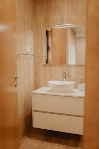 a bathroom with a white sink and a mirror at Antas Villa Family in Esposende