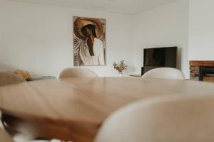 a table and chairs in a living room with a painting at Antas Villa Family in Esposende