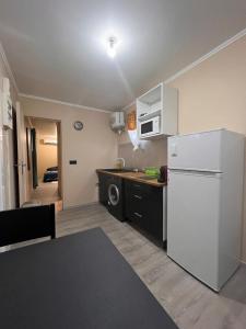 a kitchen with a white refrigerator and a microwave at Logement en pleine nature, à 15min du centre ville in Kourou