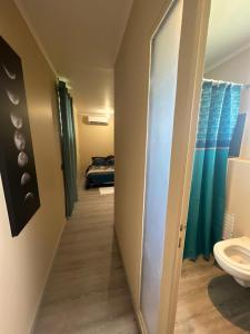- un couloir menant à une salle de bains pourvue de toilettes dans l'établissement Logement en pleine nature, à 15min du centre ville, à Kourou