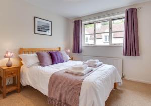 a bedroom with a bed with towels on it at Ash Cottage in Beer