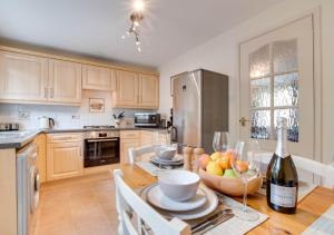 a kitchen with a table with a bottle of wine at Ash Cottage in Beer