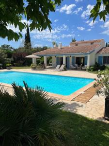 une grande piscine en face d'une maison dans l'établissement Villa Les Folies - magnifique jardin avec piscine, au Beausset