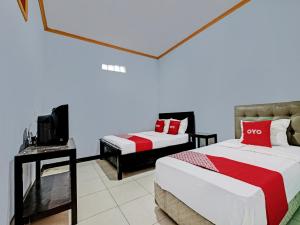 a bedroom with two beds and a tv in it at OYO 92605 Hotel Las Vegas in Kopeng