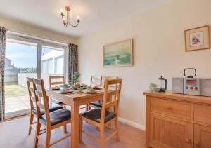 a dining room with a table and chairs and a window at Farthings in Salcombe Regis