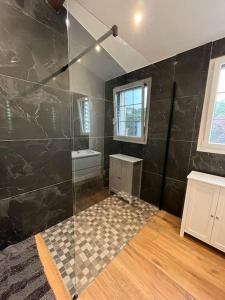 a bathroom with a shower with a glass door at Villa Les Folies - magnifique jardin avec piscine in Le Beausset