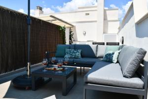 a patio with a couch and two glasses of wine at Luxurious flat & private rooftop in Villamartin Orihuela Costa in Orihuela Costa