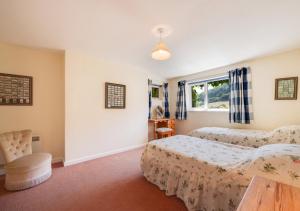 a bedroom with two beds and a window at Combe Way Cottage in Branscombe
