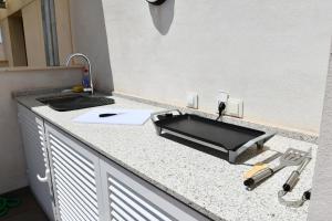 eine Küchentheke mit einer Spüle und einer Arbeitsplatte in der Unterkunft Luxurious flat & private rooftop in Villamartin Orihuela Costa in Orihuela