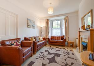 a living room with leather furniture and a fireplace at Glenisla in Sidmouth